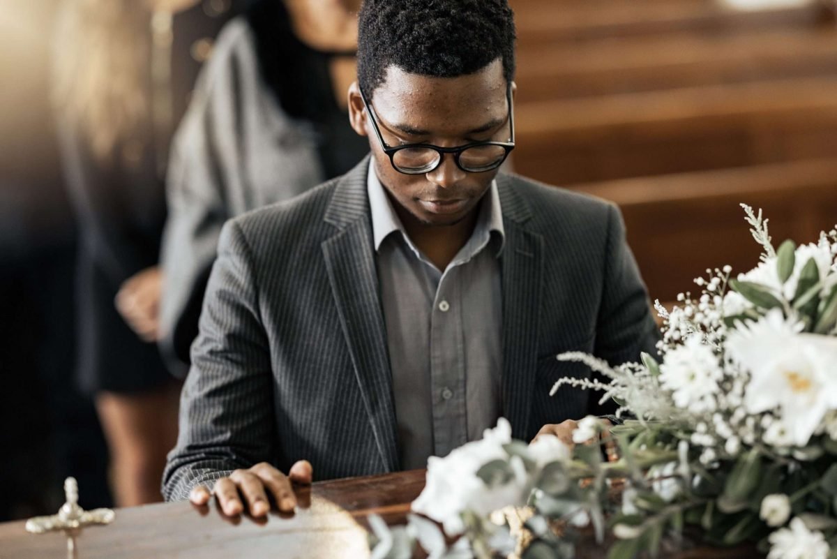 funeral-coffin-death-and-black-man-sad-grieving-2023-11-27-05-09-49-utc Funeral coffin, death and black man sad, grieving and mourning loss of family, friends or dead love.